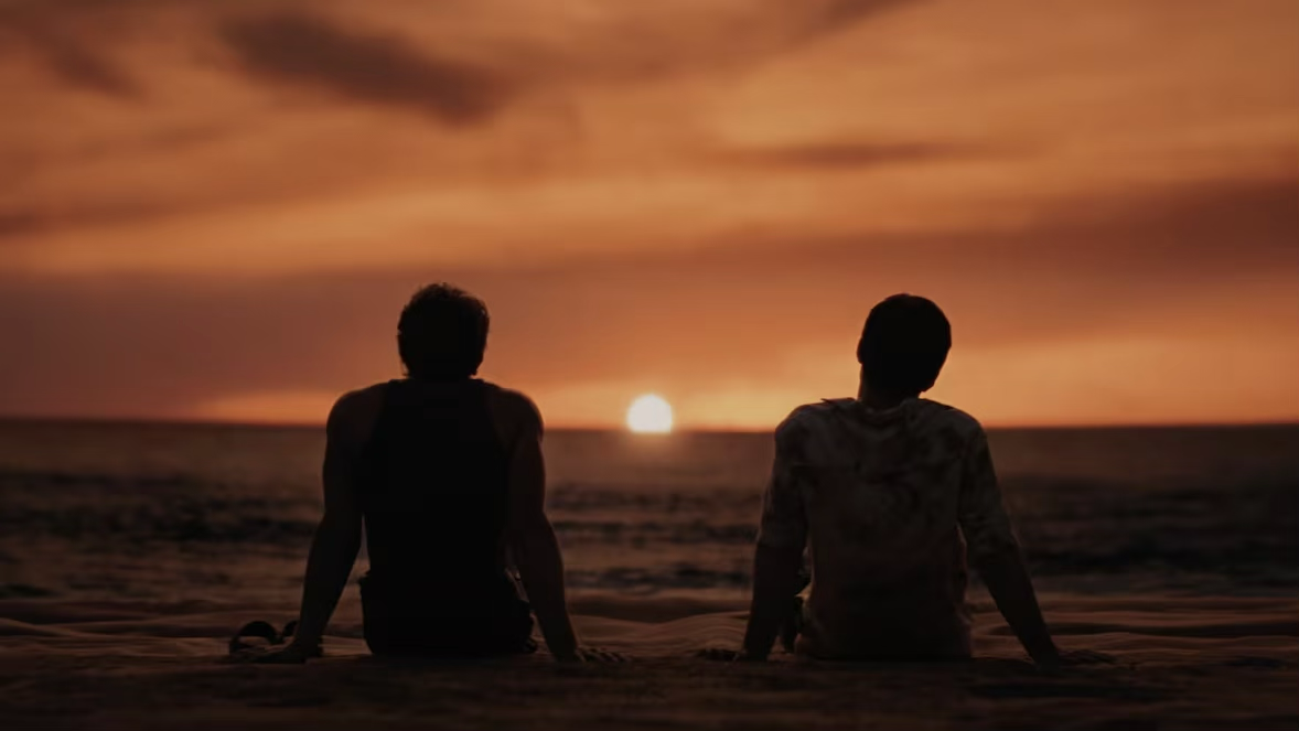 Ilya and Shane sitting on the beach together in Episode 5 | Still from HBO Max